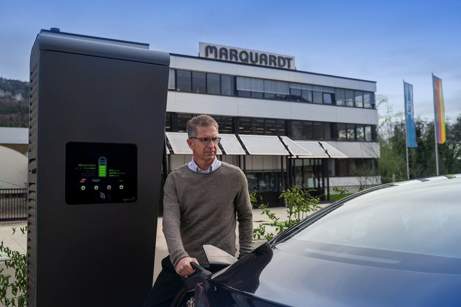 Jochen Schweickhardt, Prokurist und Nachhaltigkeitsbeauftragter bei Marquardt, beim Laden eines E-Autos.