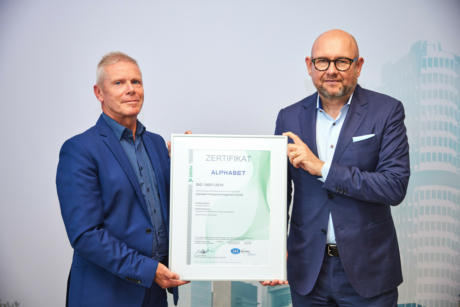 Frank Barenscheer, Head of Sales der Dekra, übergab Uwe Hildinger, Geschäftsführer von Alphabet Deutschland, die ISO-14001-Zertifizierung.