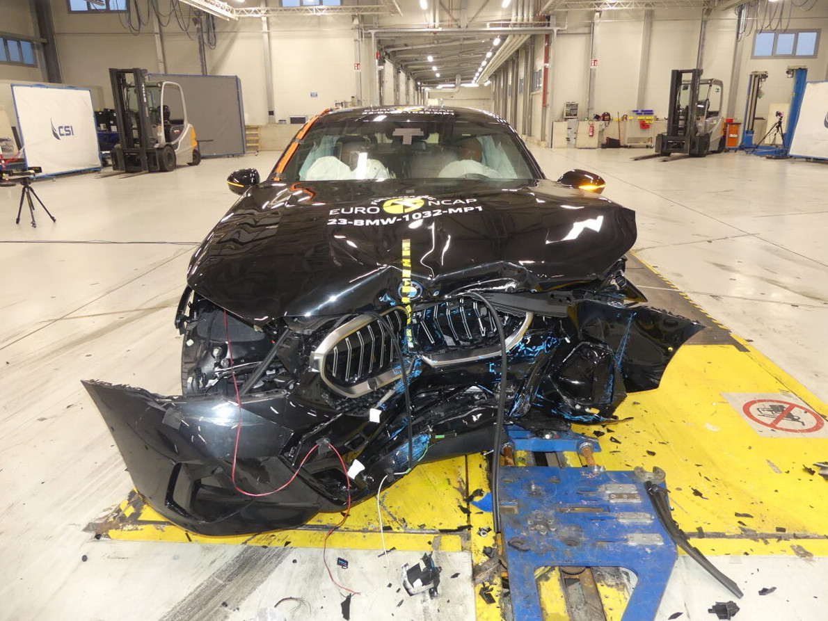 Ein schwarzer BMW mit zerstörter Front im Rahmen eines Crash-Test.